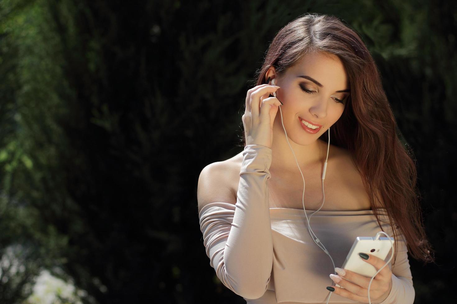 niña sonriente escuchando música en el teléfono móvil foto