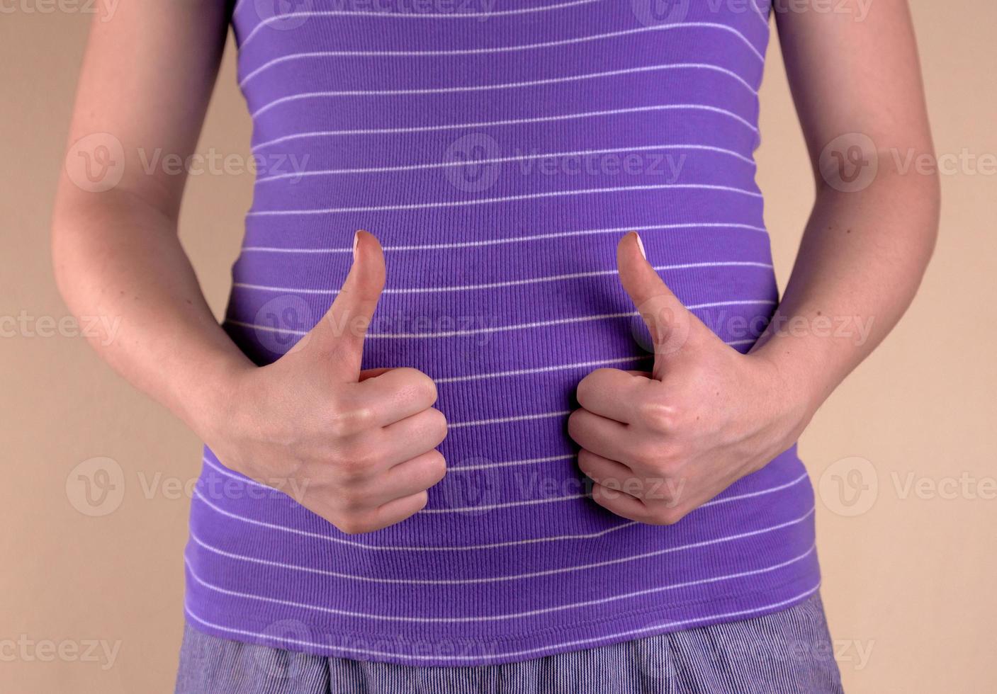 A close up view of the belly of a pregnant woman shows a like sign photo