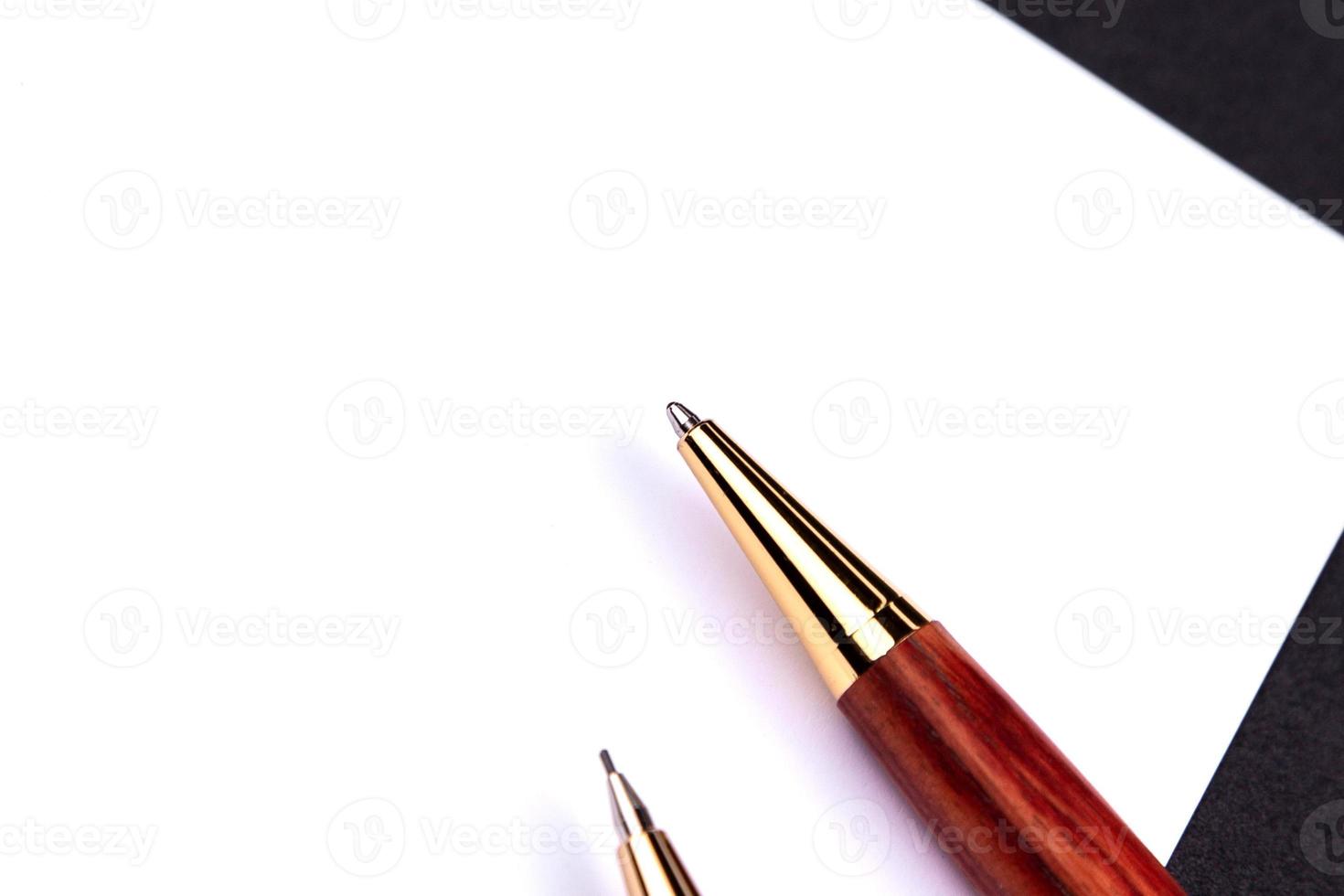 Luxury pen and mechanical pencil in wood and gold with a white sheet of paper photo