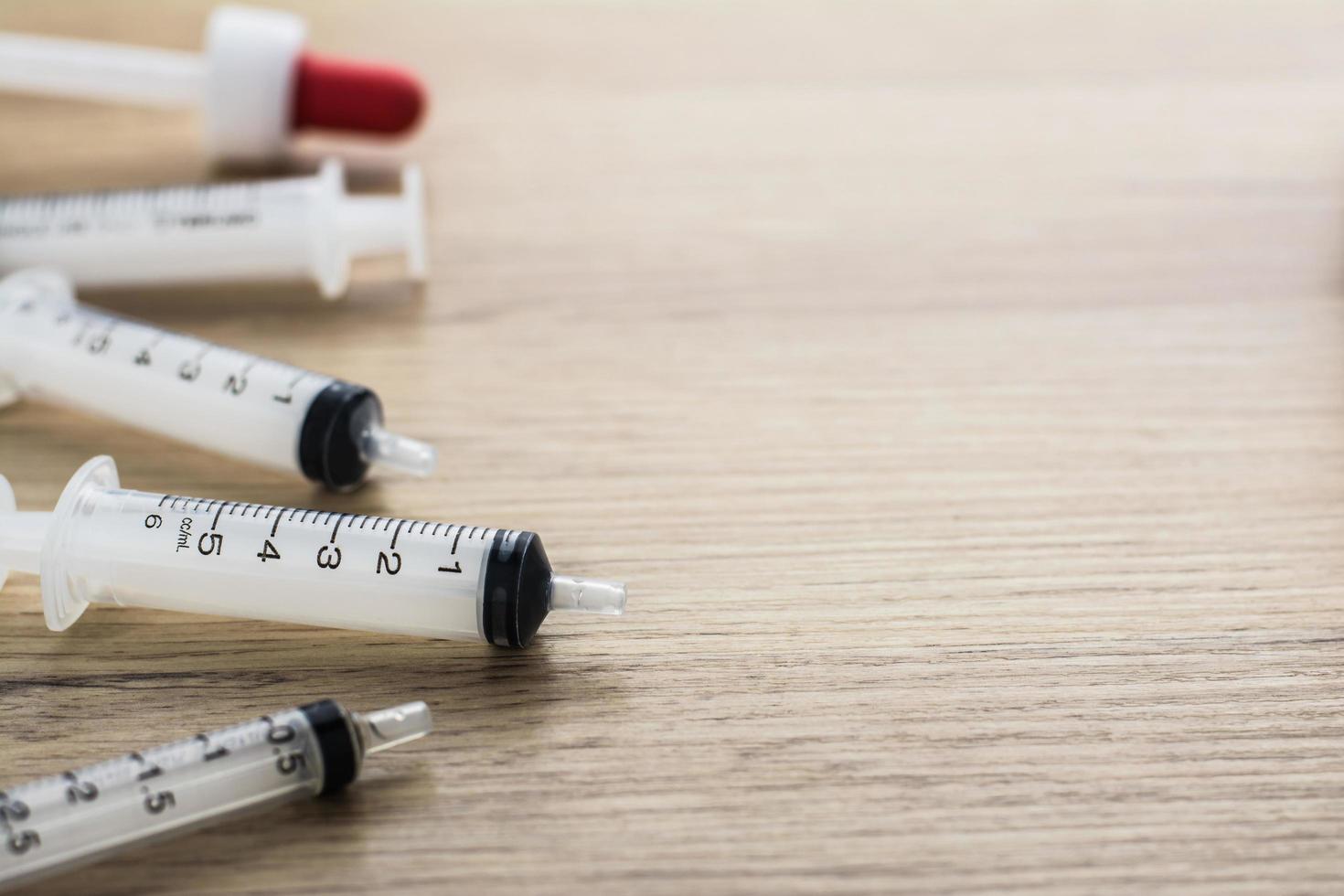 Empty syringes barrel on the wooden table with copy space photo