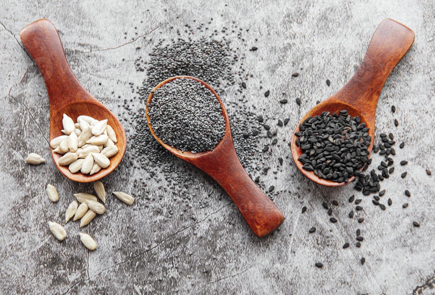 Wooden spoons with various healthy seeds photo