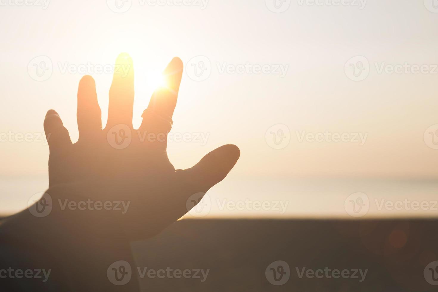 Hand reach out to sunset sky beach sand nature background relax and rest in vacation photo