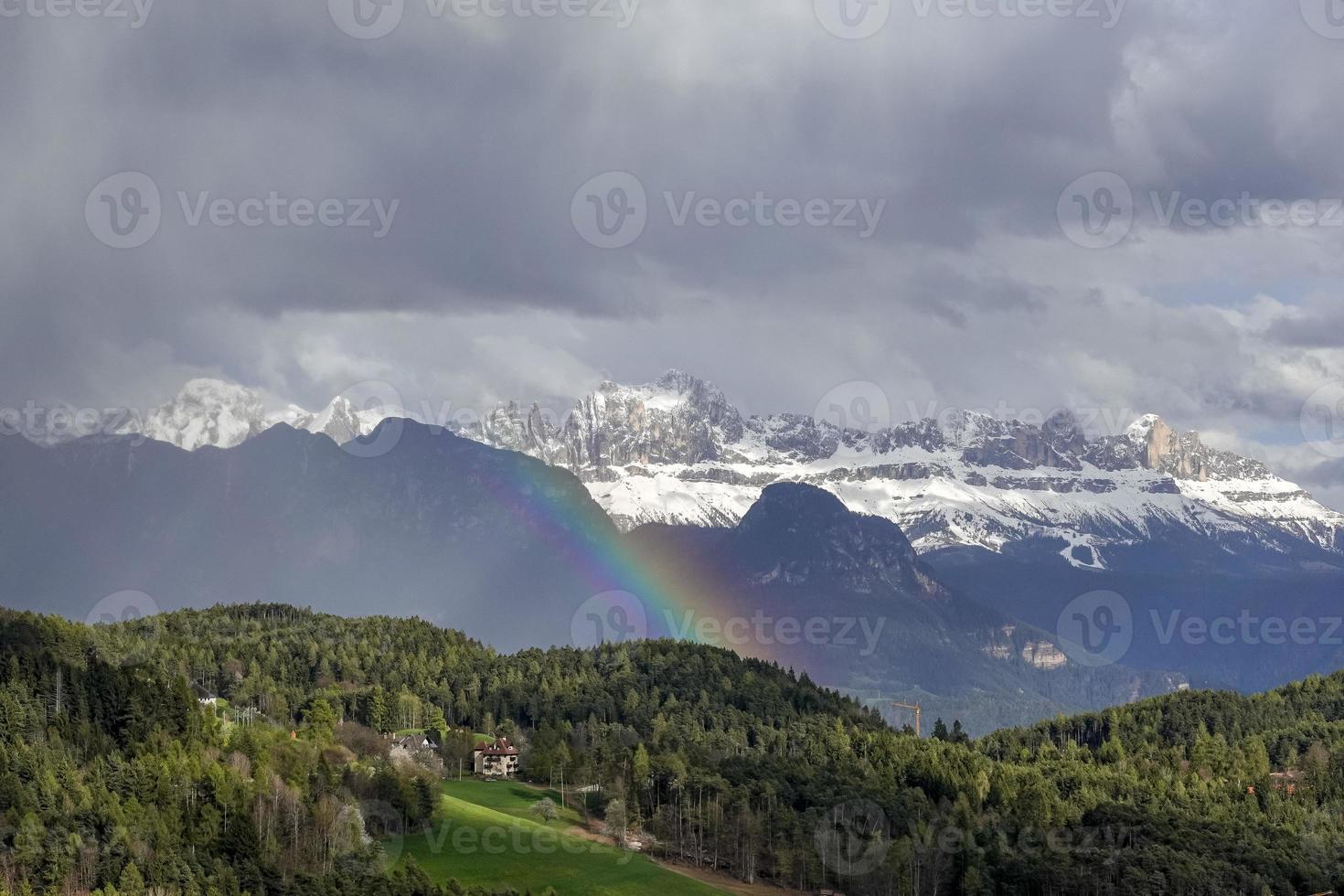 heavy rain with rainbow in the snowy high mountains photo