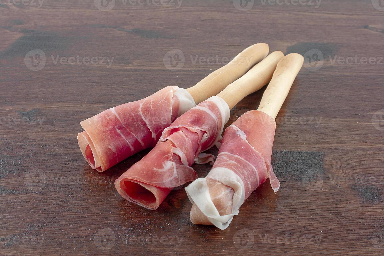 Jamón crudo envuelto en palitos de pan foto