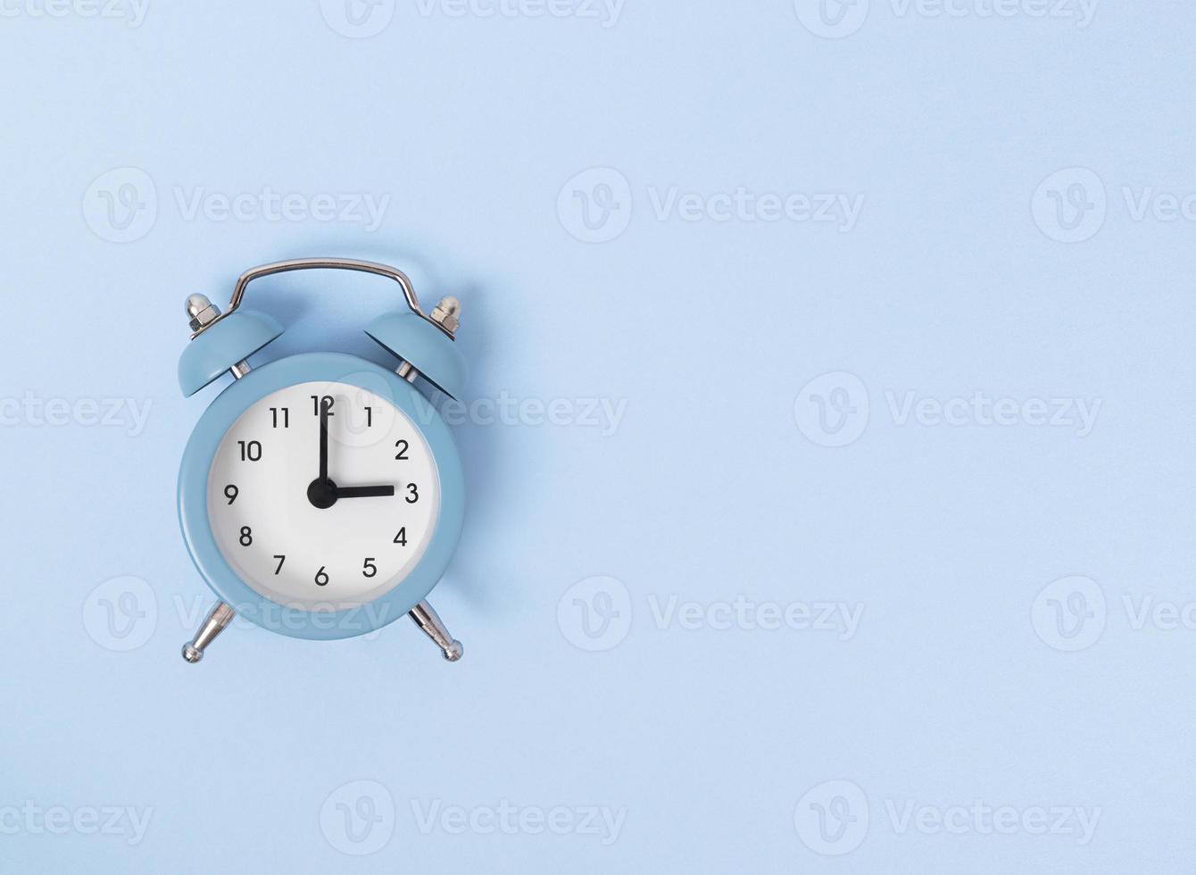 Despertador retro sobre fondo azul monocromo plano simple lay con copia espacio tiempo concepto stock photo foto