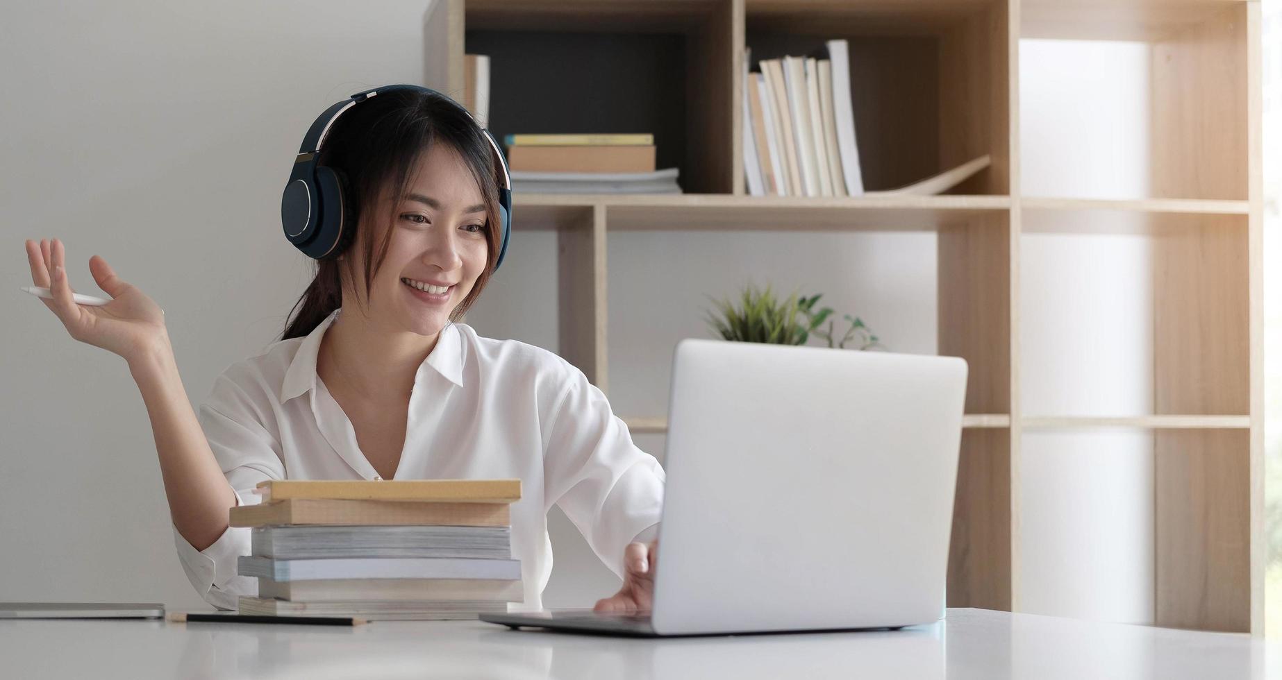 Side view head shot smiling mixed race lady wearing headset communicating with client via video computer call photo