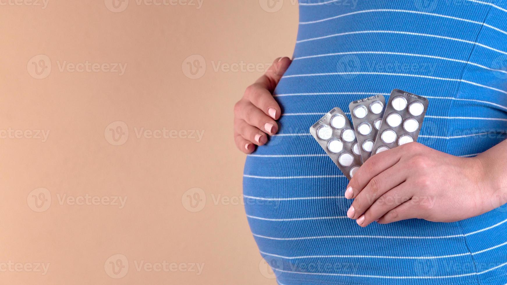 Una vista de cerca del vientre de una mujer embarazada en un azul foto