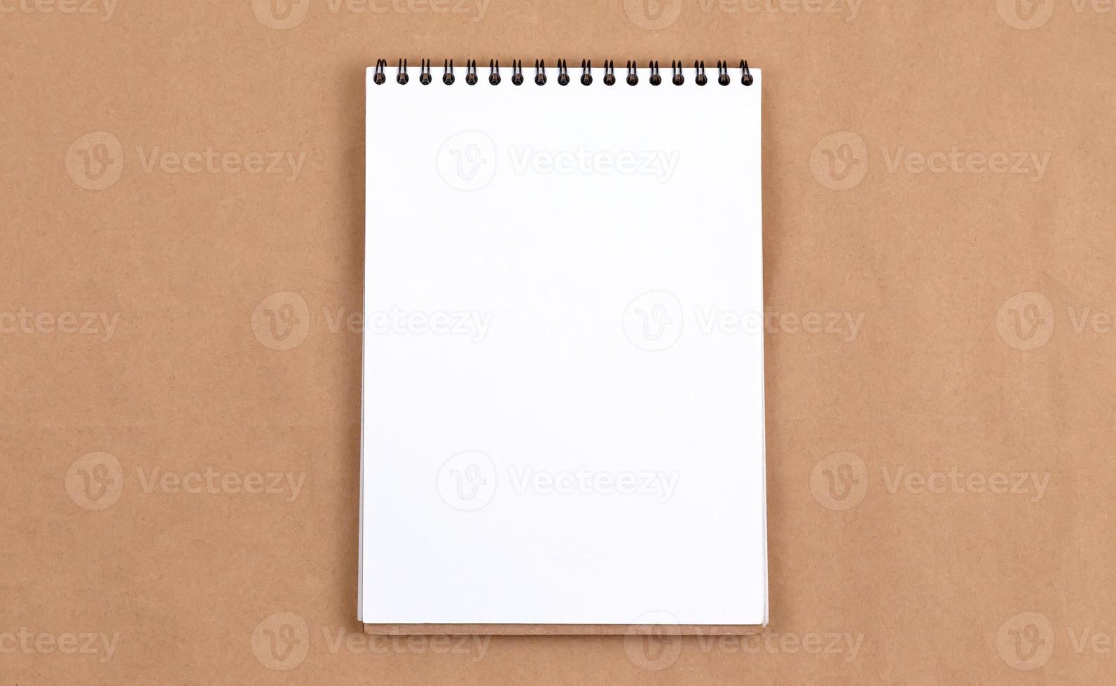 Flat lay top view photo of blank notepad on a beige abstract background with copy space