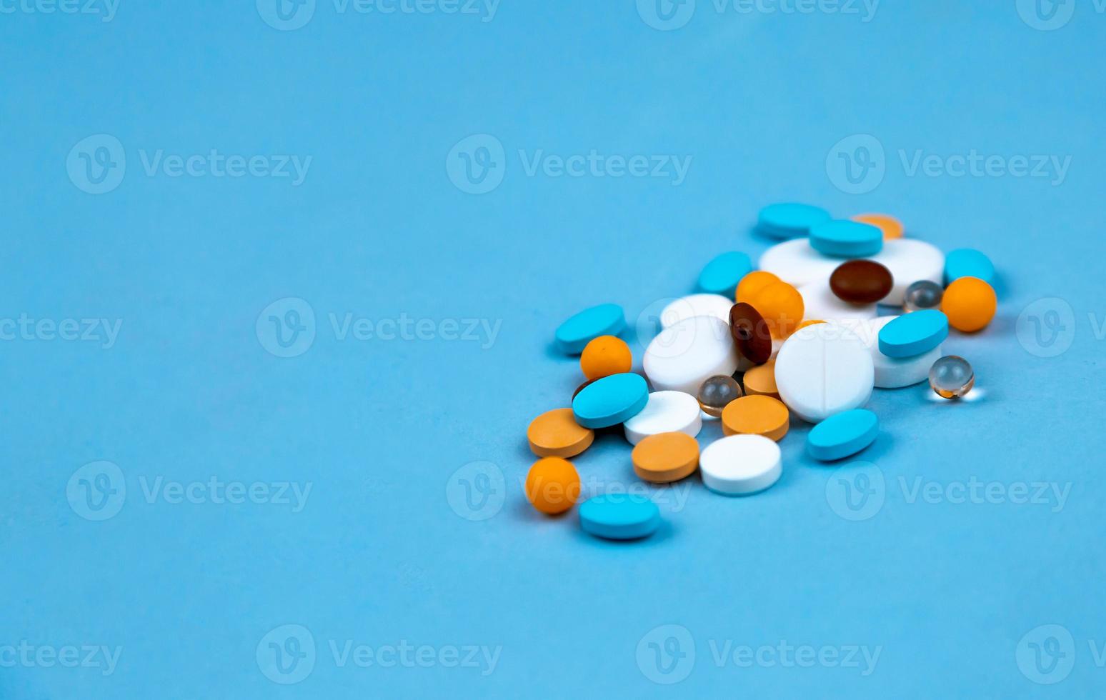 Multi colored pills on a blue background close-up photo