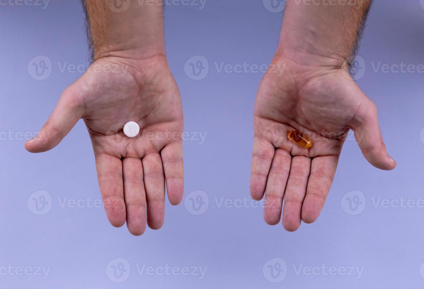manos de hombre dando dos pastillas grandes foto