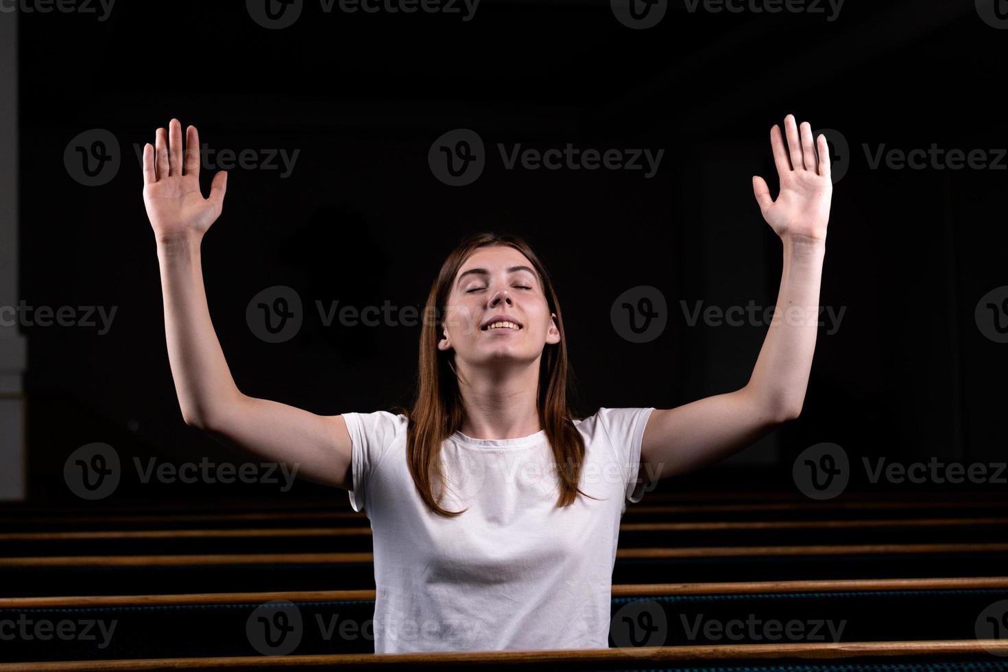 una niña cristiana con camisa blanca está orando con corazón humilde en la iglesia foto