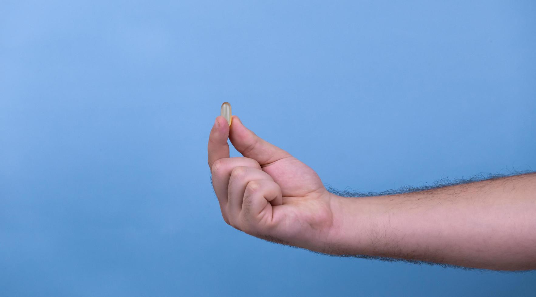 One pill in a male hand photo