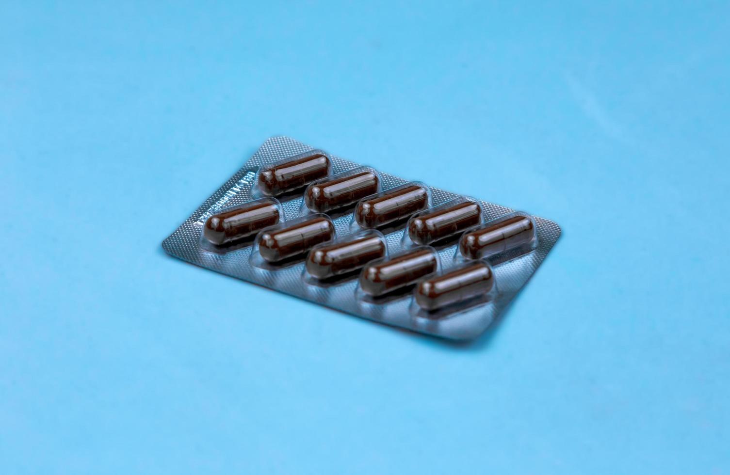 Pills in plastic package on blue background photo