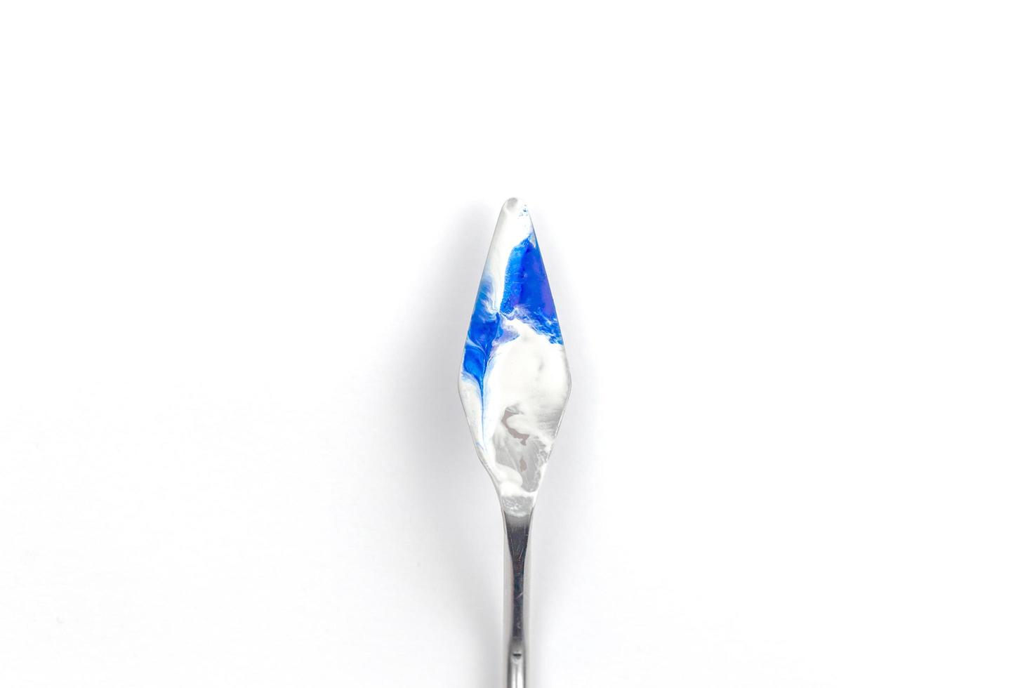 Una espátula de pintura aislada sobre un fondo blanco pintura azul verde azulado foto