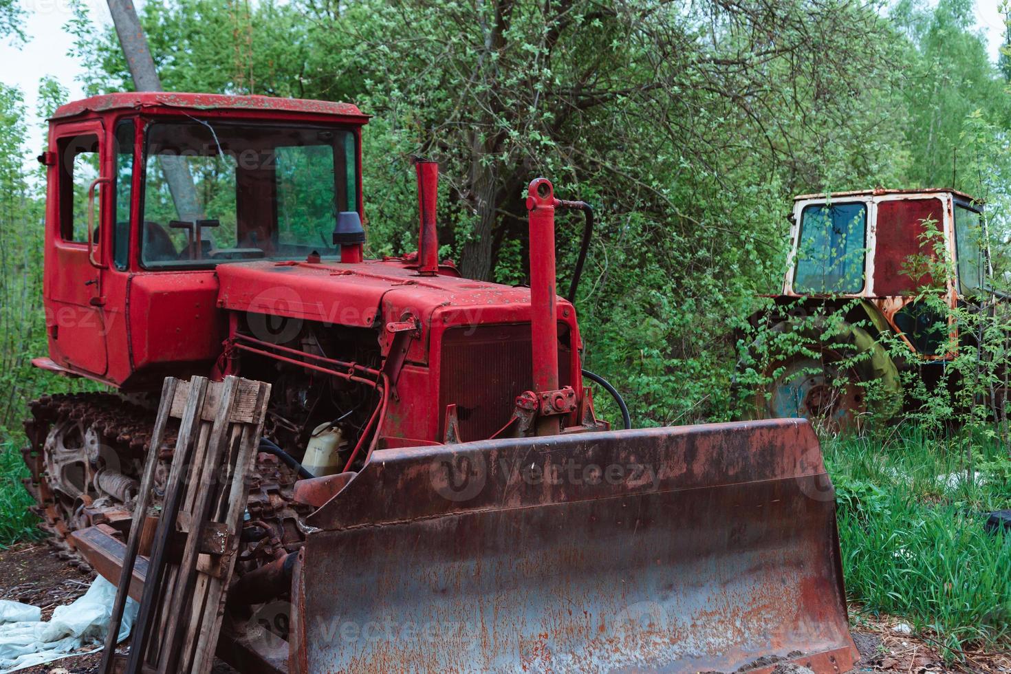 Tractores viejos y otro material agrícola en un depósito de chatarra foto