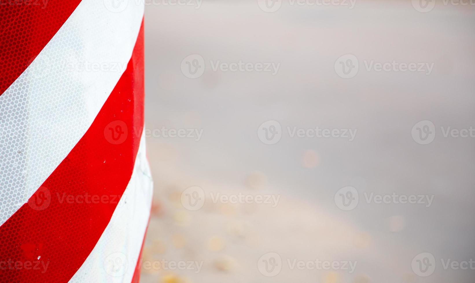 Red and white striped concrete road barrier close-up with copy space for text photo