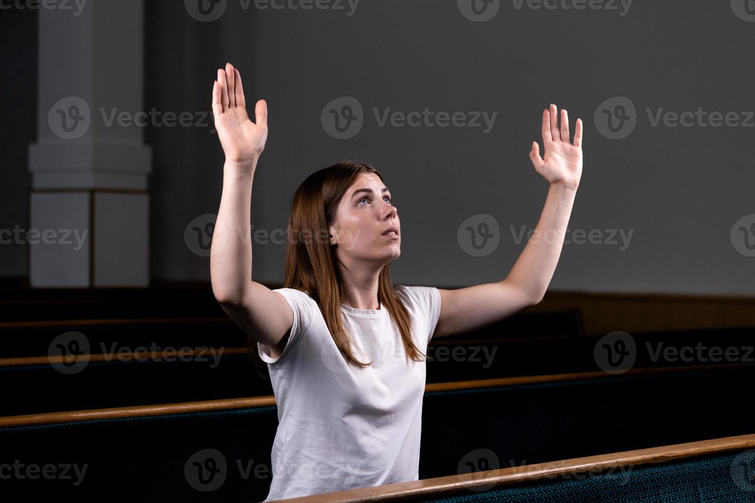 niña cristiana rezando con corazón humilde en la iglesia foto