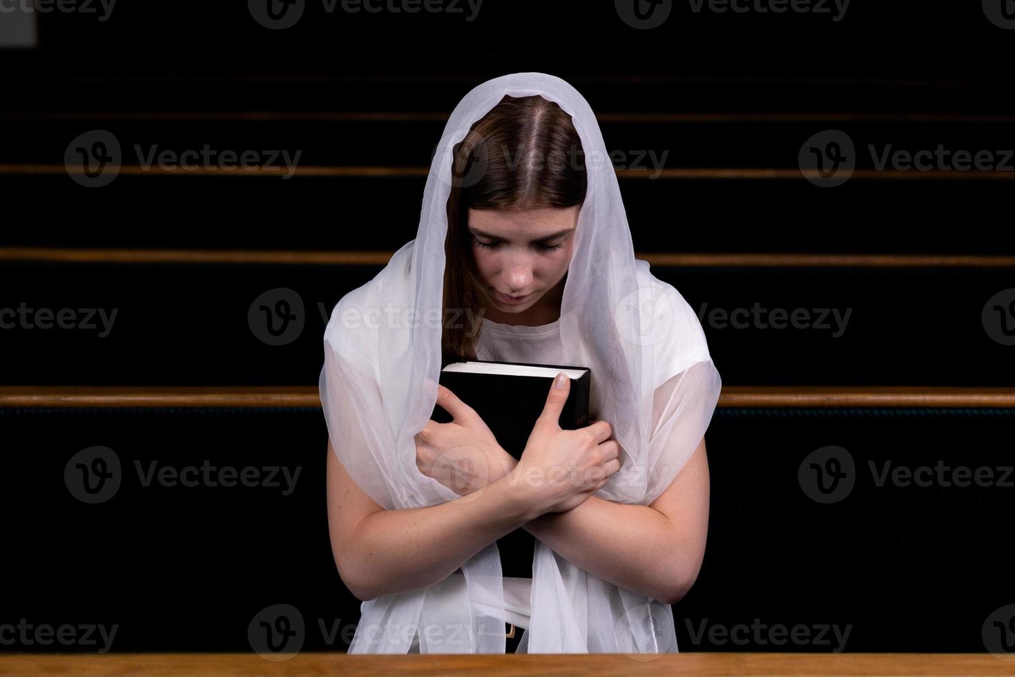 niña cristiana rezando con corazón humilde en la iglesia foto