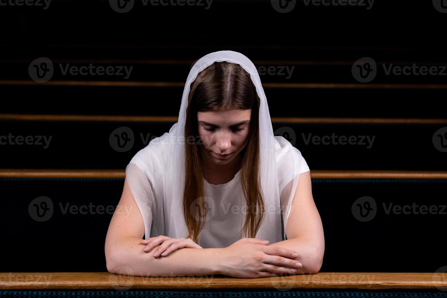 niña cristiana rezando con corazón humilde en la iglesia foto