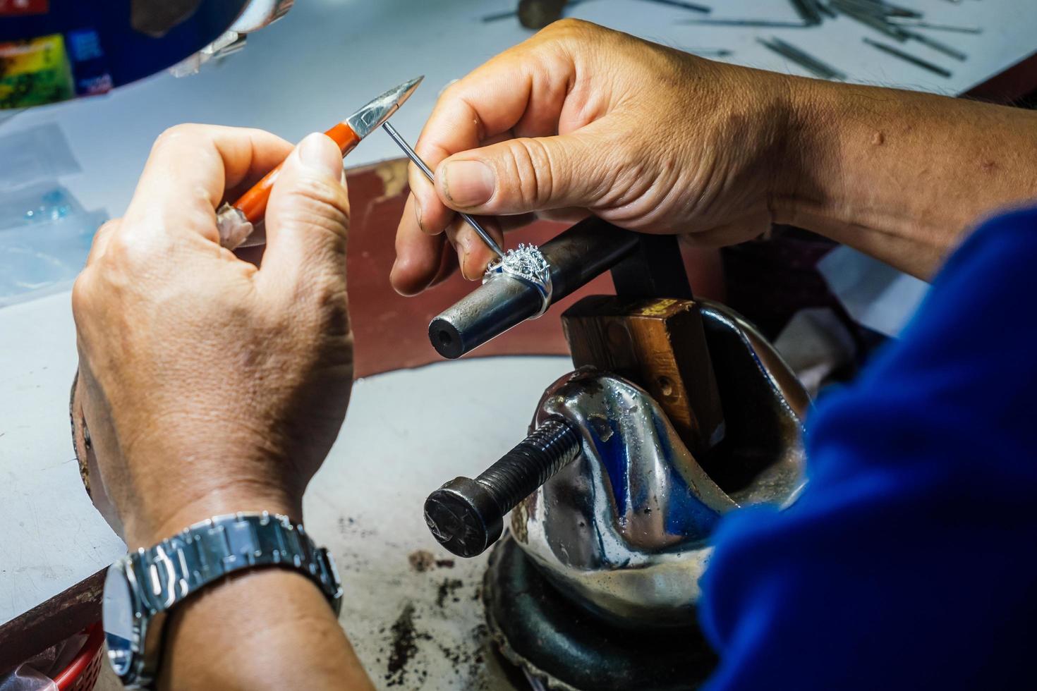 Close up of a goldsmith hand making silver ring photo