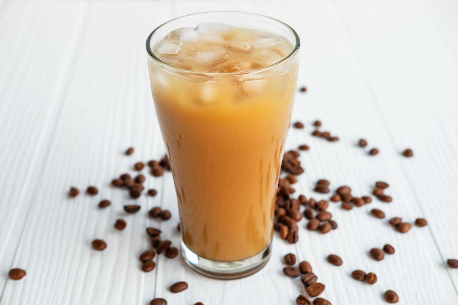 Iced coffee in a glass on a white wooden background photo
