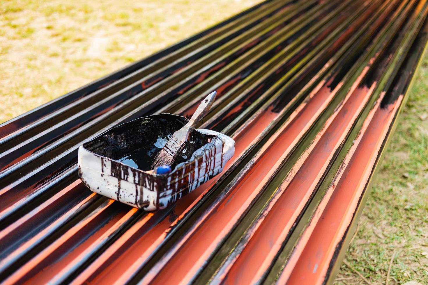 Paintbrush on paint bucket for painting steel, tape for protecting against rust. photo