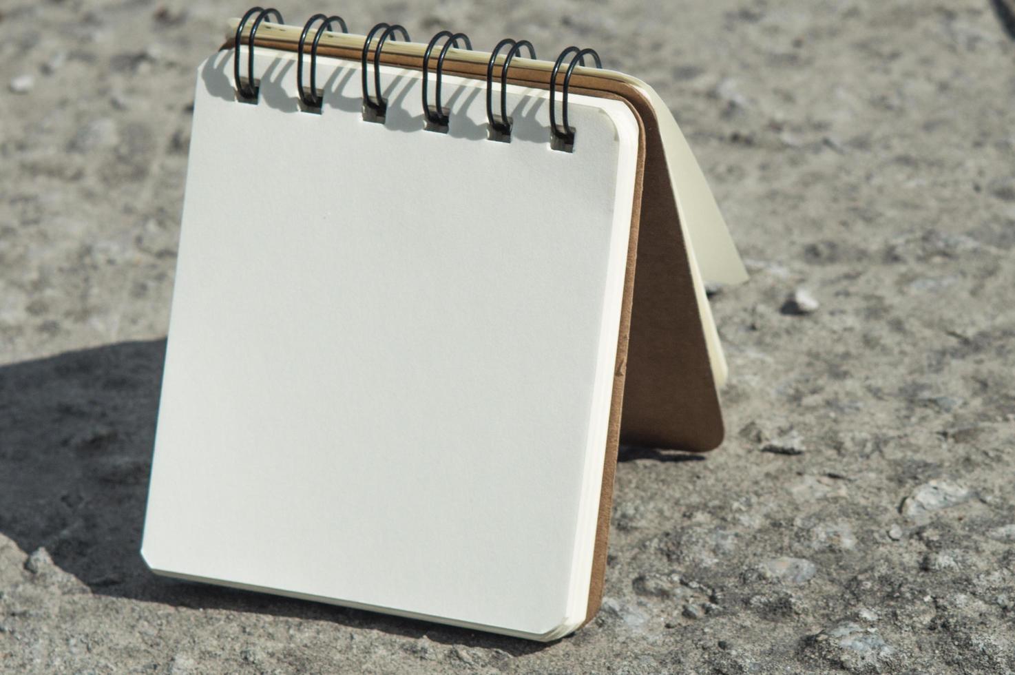 Notebook with white paper on the ground photo