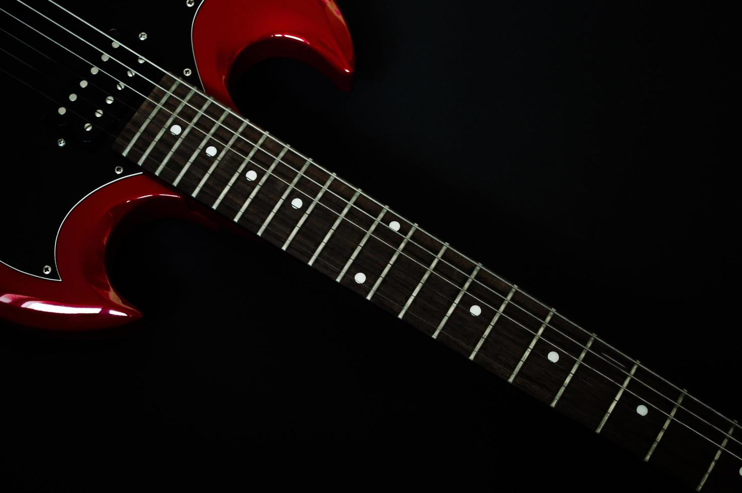 Primer plano de la guitarra eléctrica roja sobre fondo negro foto