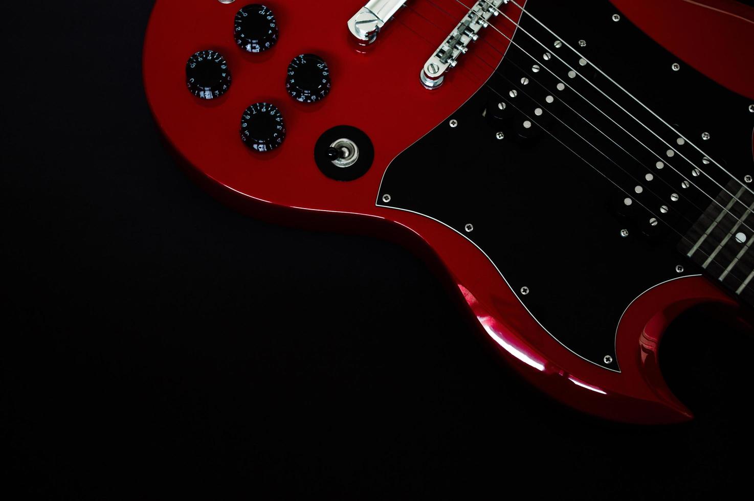 Red electric guitar closeup  on black background photo