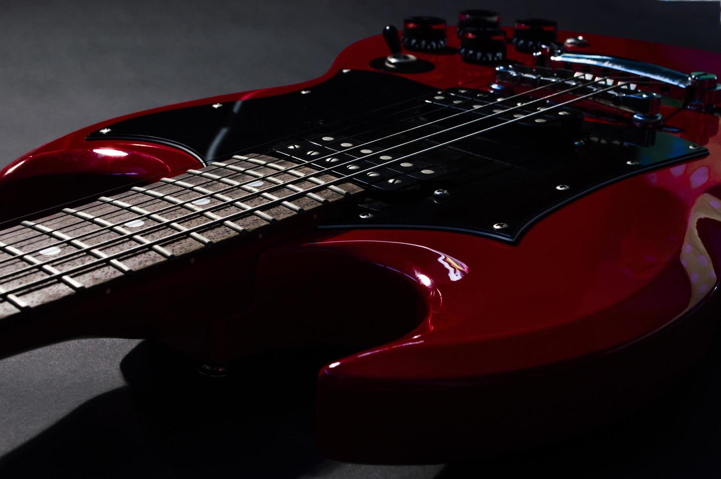 Red electric guitar closeup  on black background photo