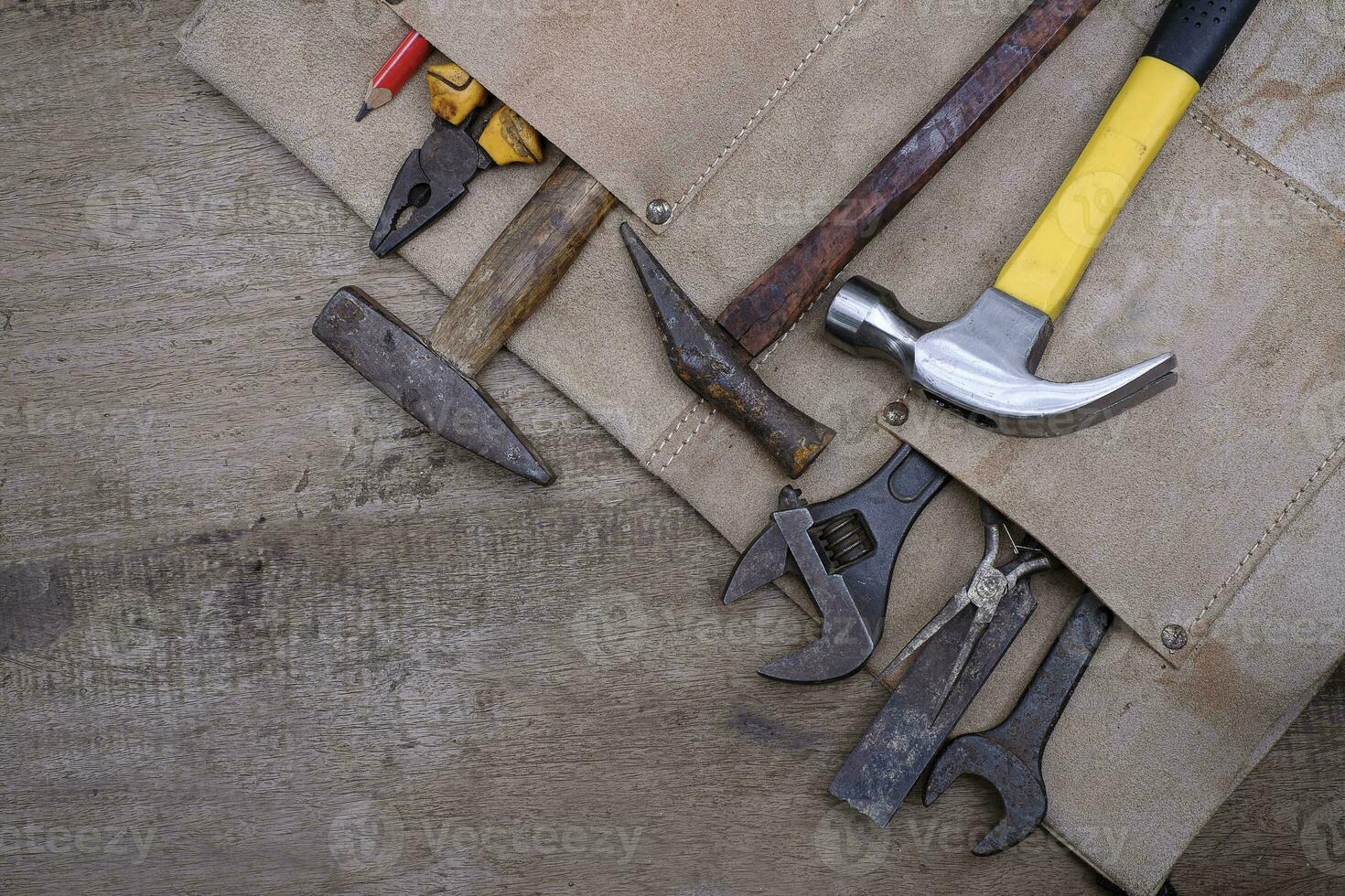 Collection of woodworking old hand tools in leather apron on a rough wooden workbench photo