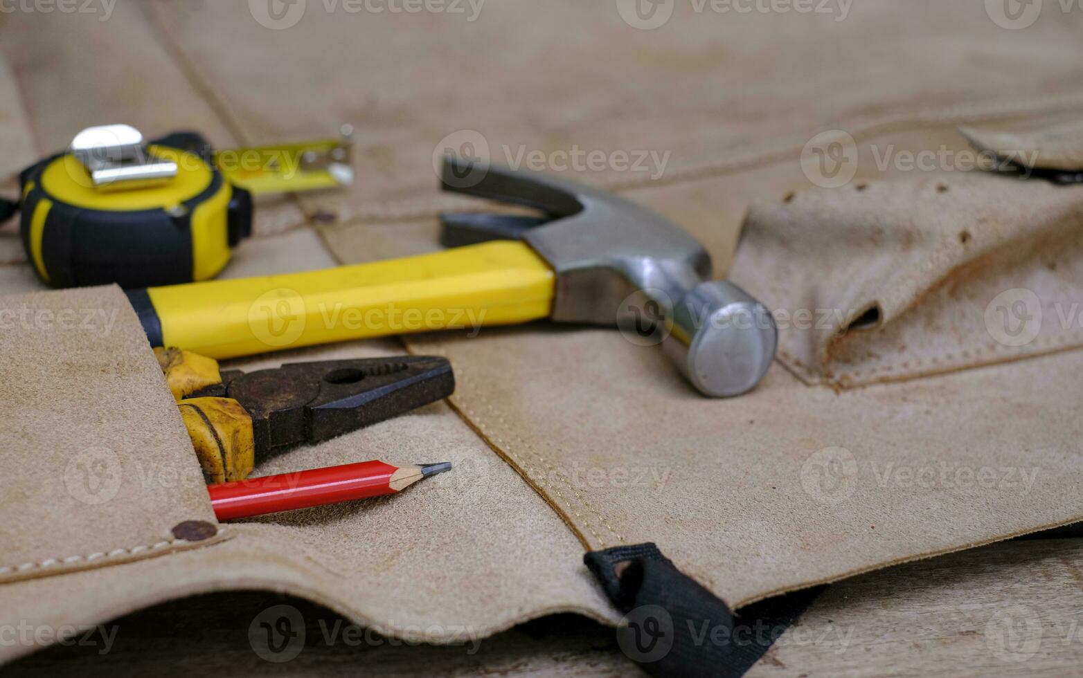 Colección de herramientas de mano antiguas para trabajar la madera en el delantal de cuero sobre un banco de trabajo de madera rugosa foto