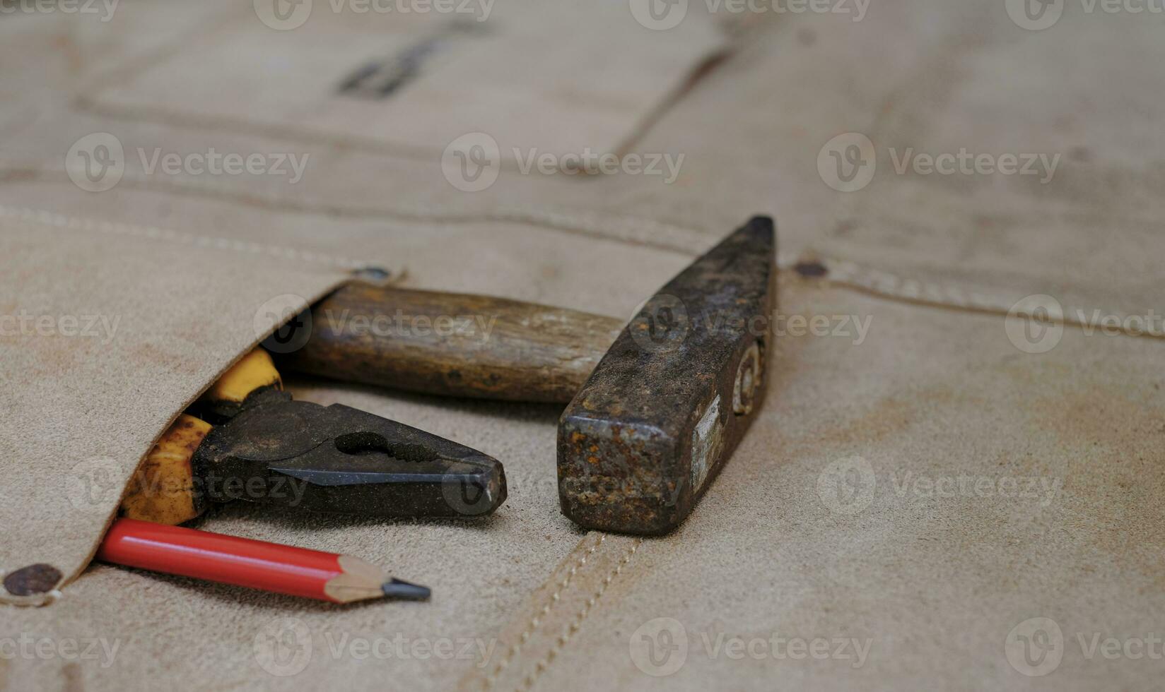 Colección de herramientas de mano antiguas para trabajar la madera en el delantal de cuero sobre un banco de trabajo de madera rugosa foto