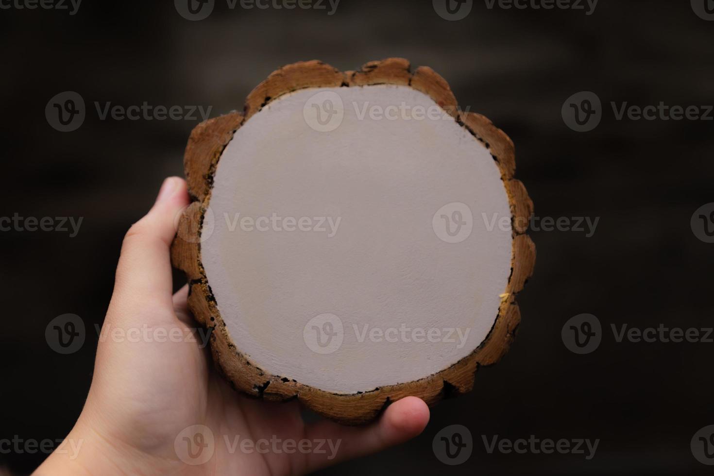 Woman's hand holding empty circular piece of wood section photo