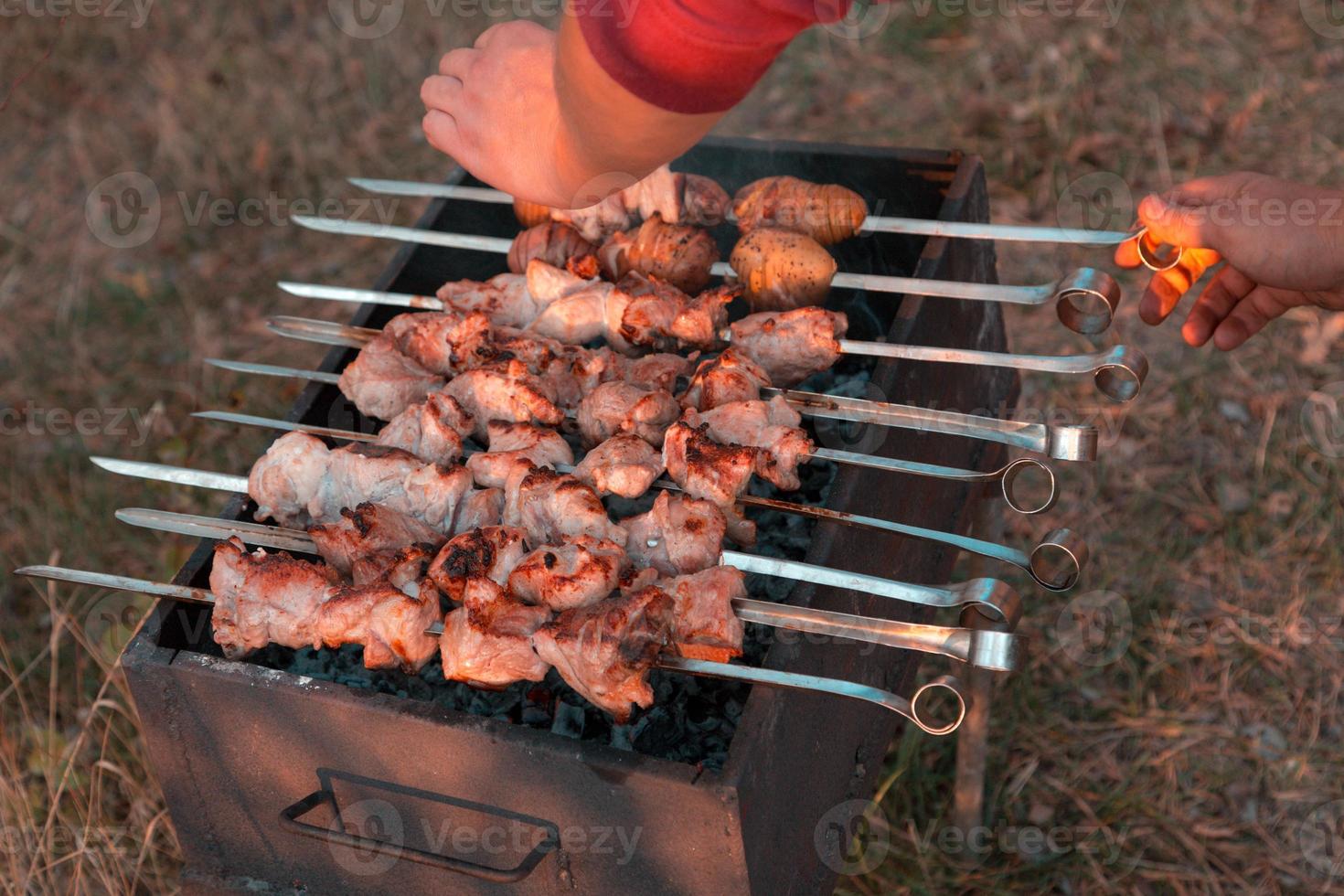 Hombre friendo shish kebab a la parrilla foto