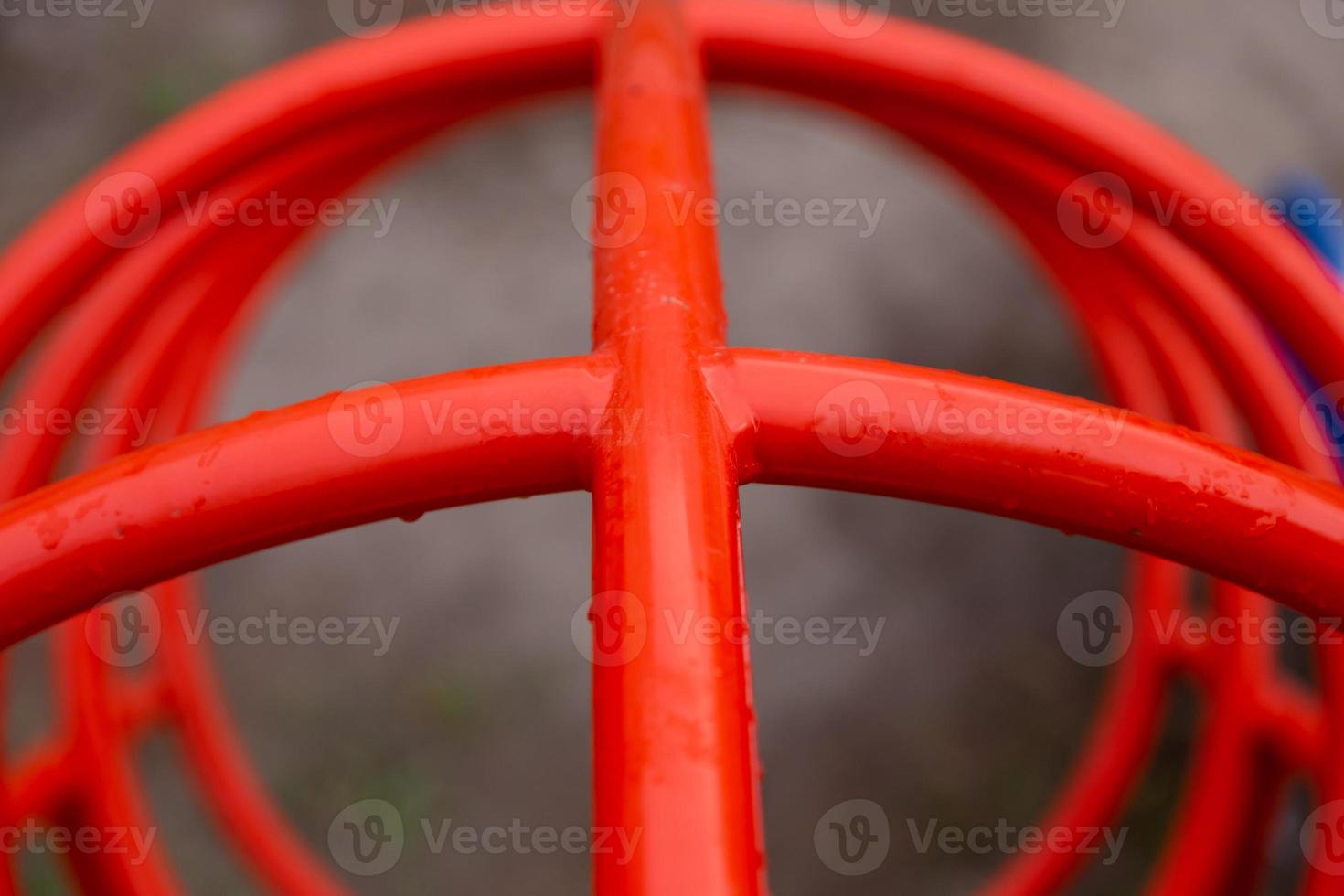 Tubos rojos en el patio de recreo de cerca en gotas de lluvia foto