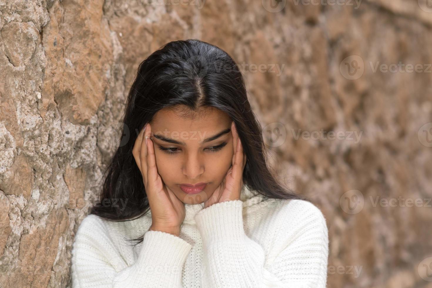 Close up portrait of a brunette woman rubbing her temples to alleviate an awful headache photo