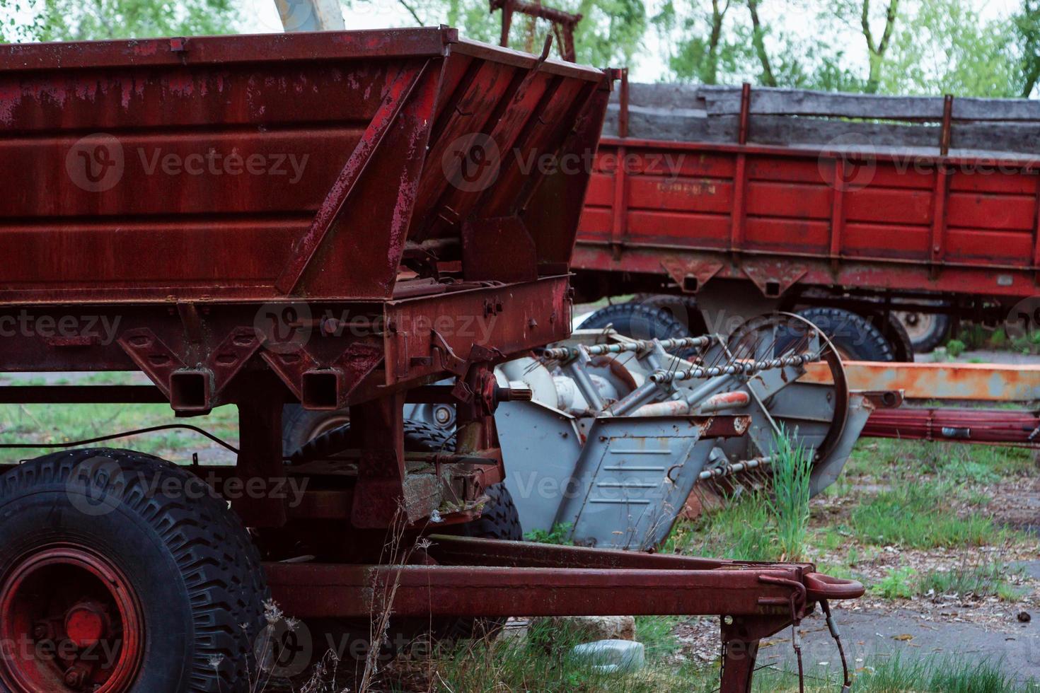 Old tractors and other farm material on a scrap yard photo