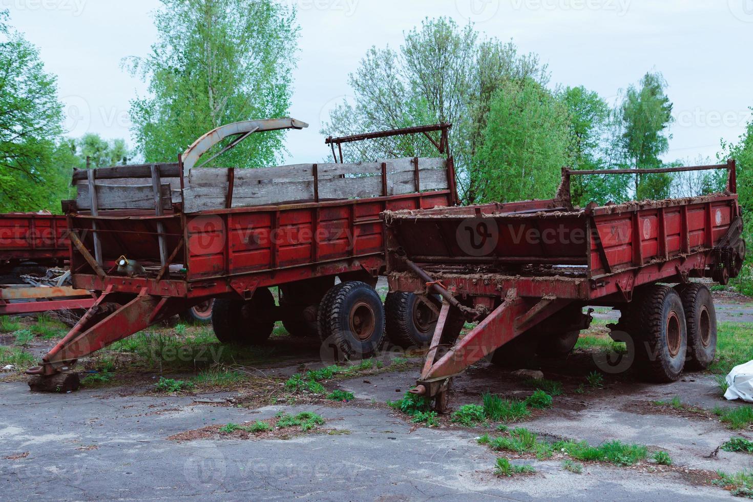 Old tractors and other farm material on a scrap yard photo