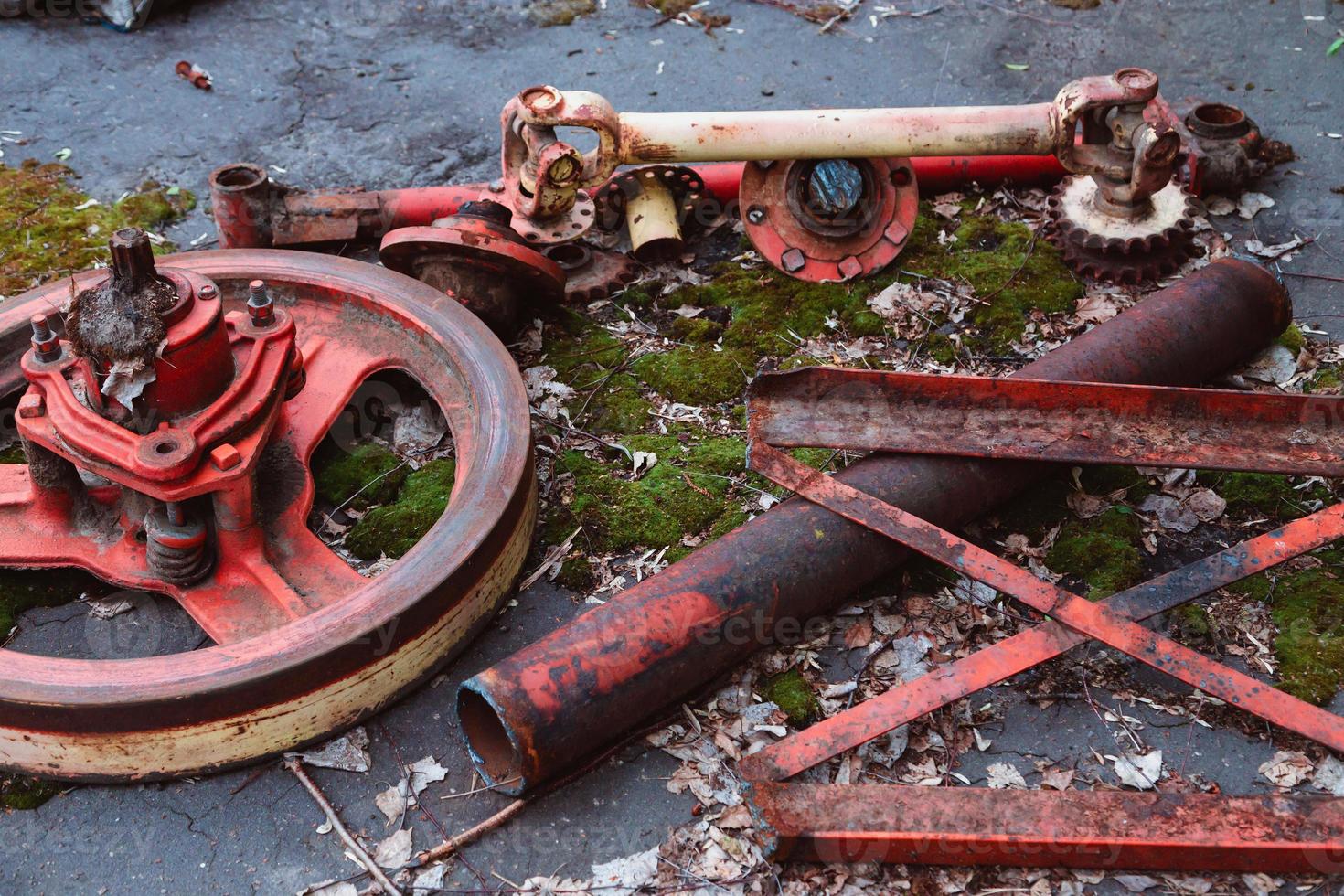 Old tractors and other farm material on a scrap yard photo