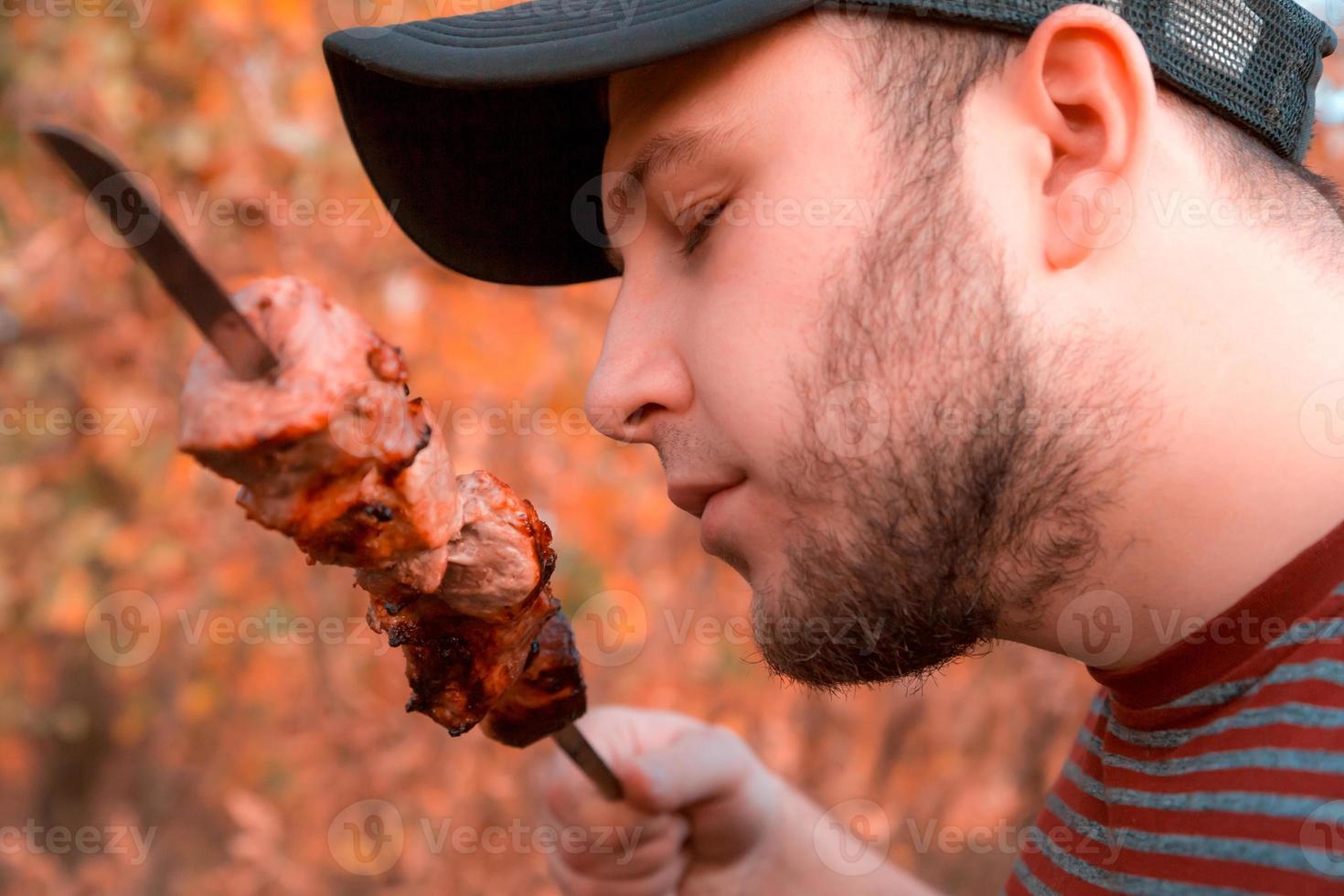 el hombre está comiendo shish kebab foto