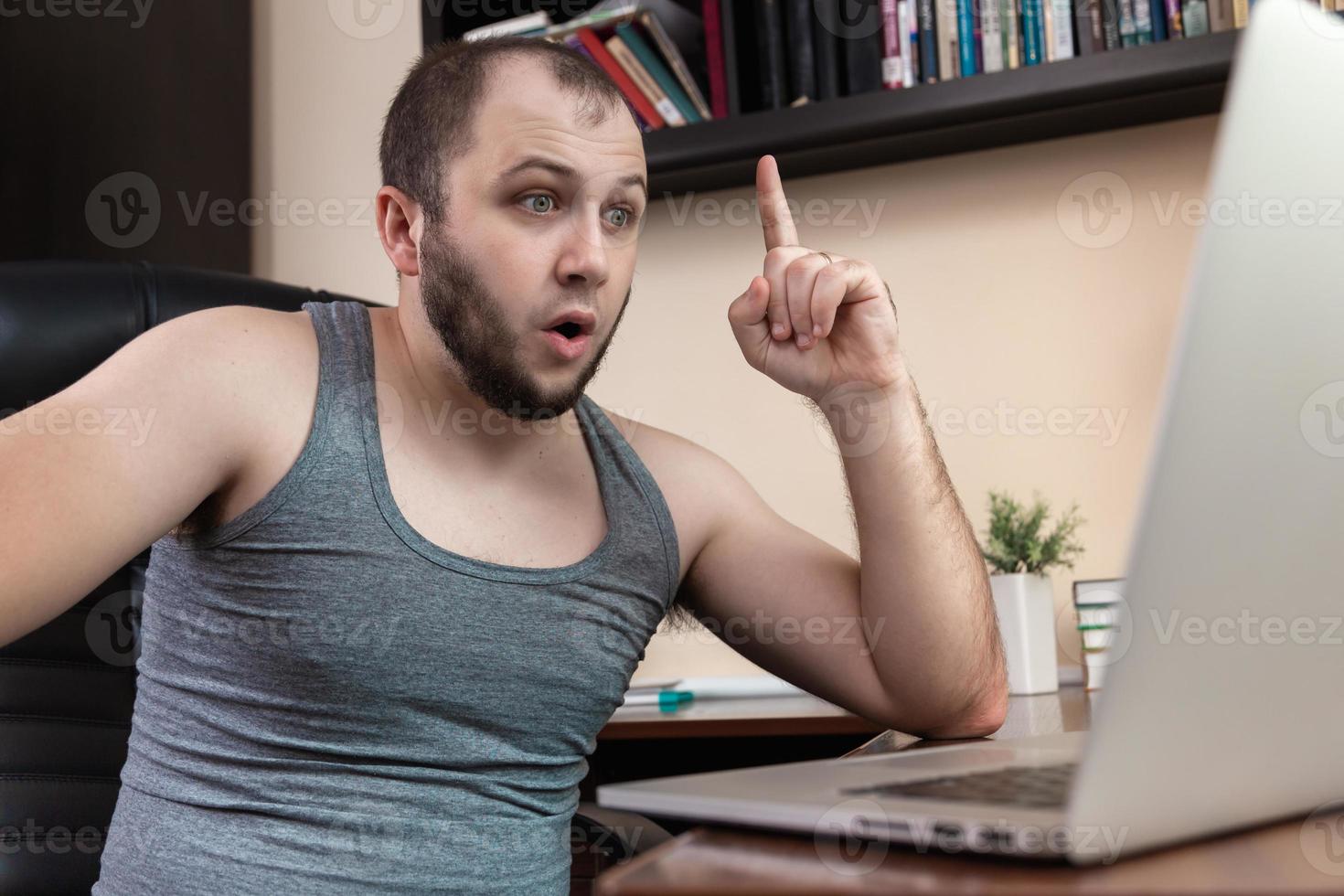 Young bearded guy leisurely using laptop photo