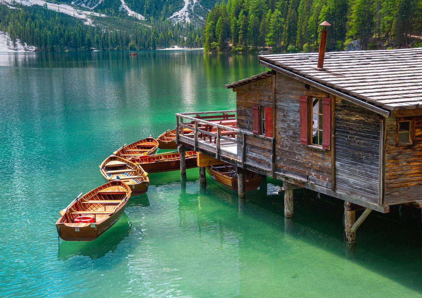 close up of iconic boathouse and boats with mount Seekofel mirroring in the clear calm water of  Pragser Wildsee Lago di Braies in Dolomites Unesco World Heritage photo