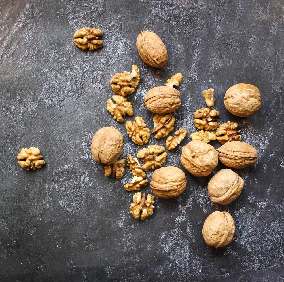 Walnut in wooden bowl on black background with copy space photo