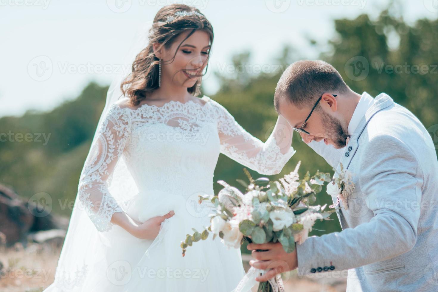 Wedding photo of the bride and groom in a gray pink color on nature in the forest and rocks