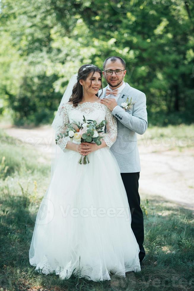 Wedding photo of the bride and groom in a gray pink color on nature in the forest and rocks