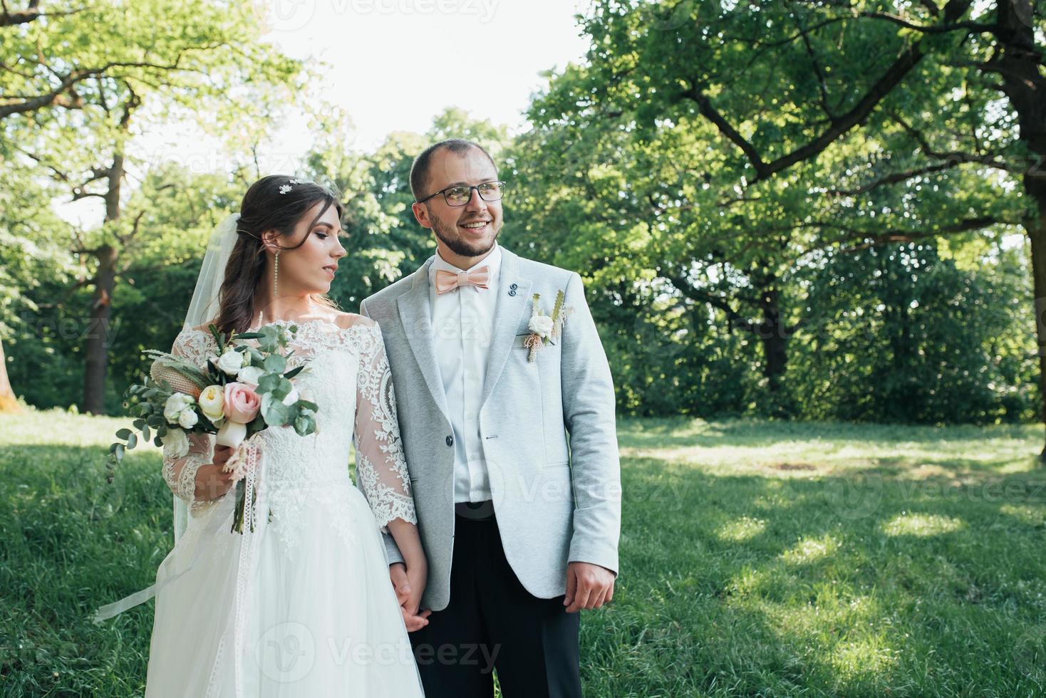 Wedding photo of the bride and groom in a gray pink color on nature in the forest and rocks