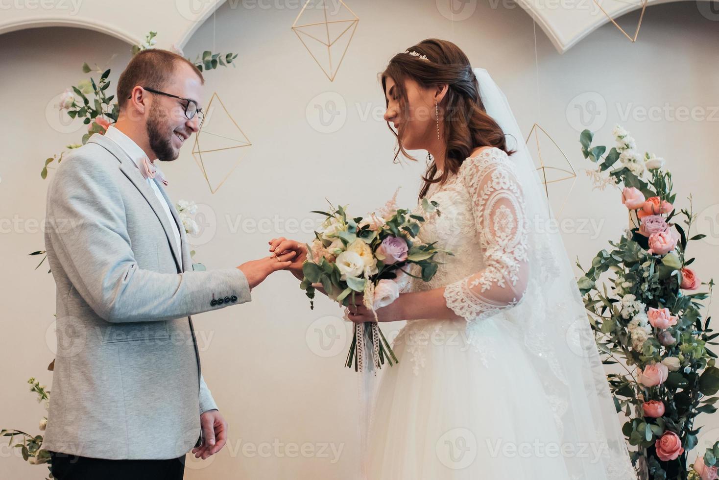 Bride and groom exchange wedding gold rings photo