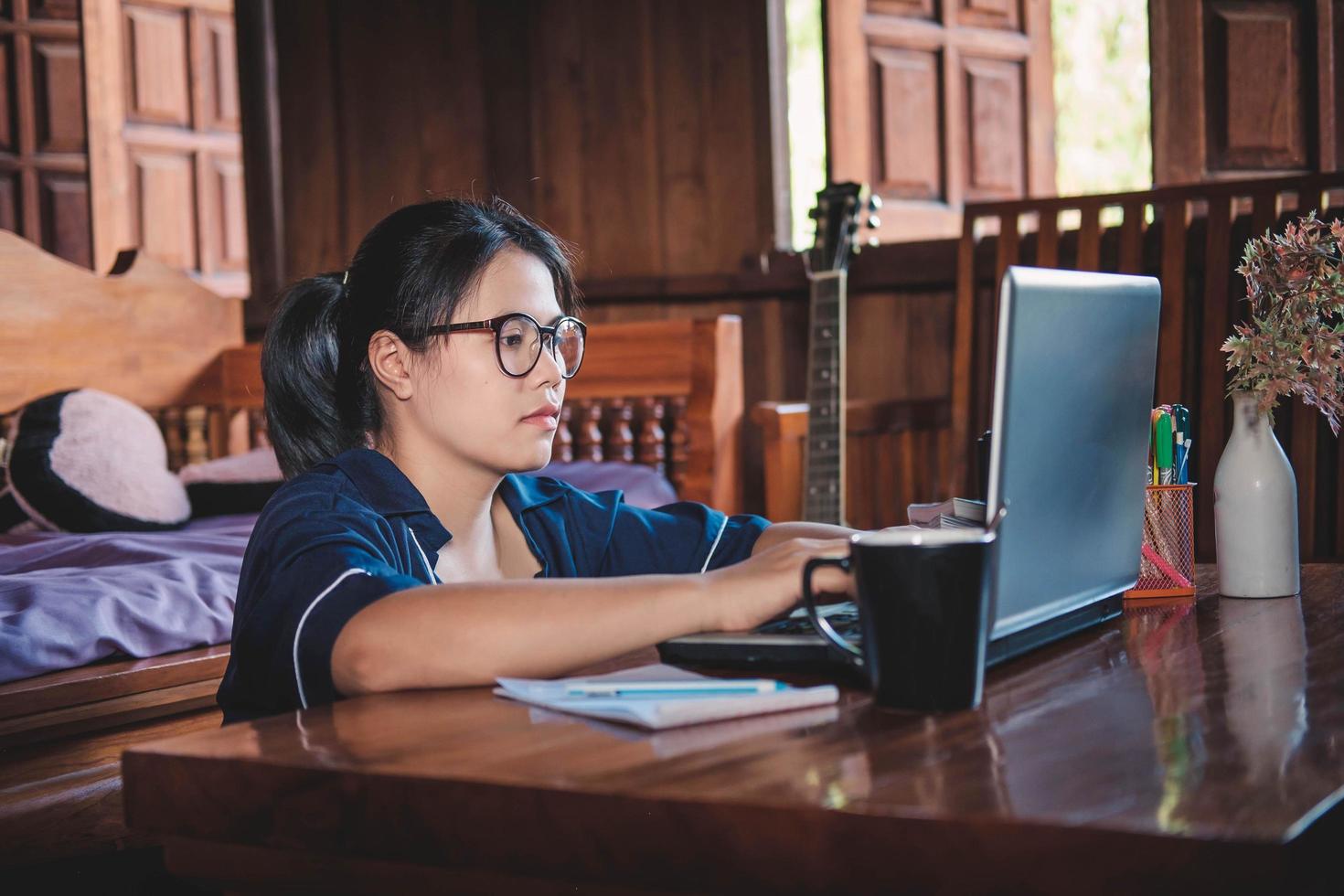 mujer joven, trabajando, sentado, en, sofá, con, computadora portátil, en casa foto