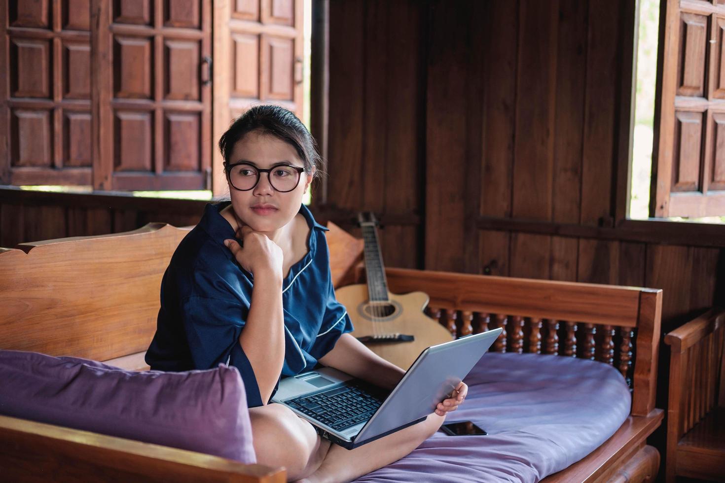 mujer joven, trabajando, sentado, en, sofá, con, computadora portátil, en casa foto